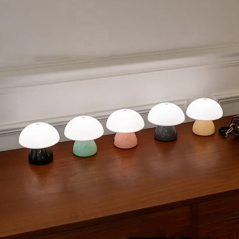 Set of five small mushroom-shaped lamps on a wooden surface with a neutral background
